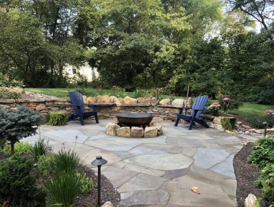 Irregular flagstone patio in Pottstown with fire pit and natural stone walls.