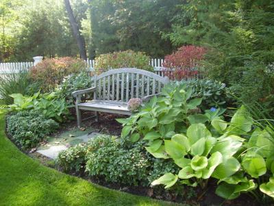 Shrubs, hostas and pachysandra surround this welcoming bench. Shrubs, hostas, and pachysandra surround this welcoming bench.