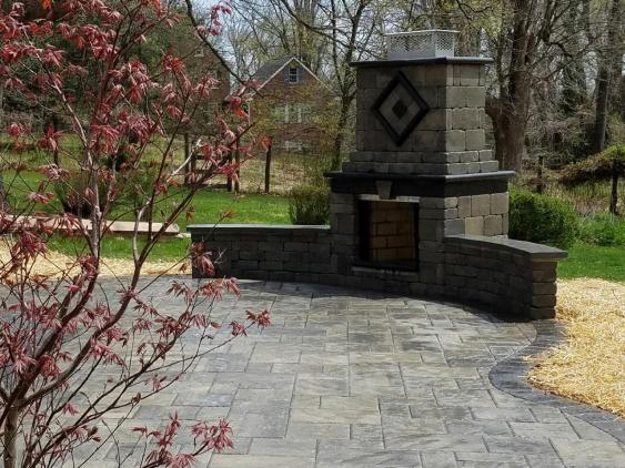 A fireplace and patio in Phoenixville, PA designed and installed by Whitehouse Landscaping.