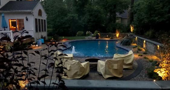 A pool and patio in Glenmoore with outdoor lighting.