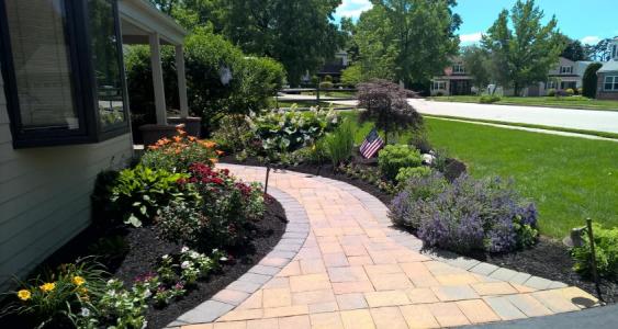 Walkway in Plymouth Meeting flanked by colorful plants and foliage.