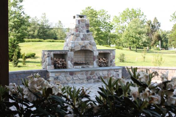 Combination concrete and veneer wall surrounding patio and fireplace in Schwenksville, PA
