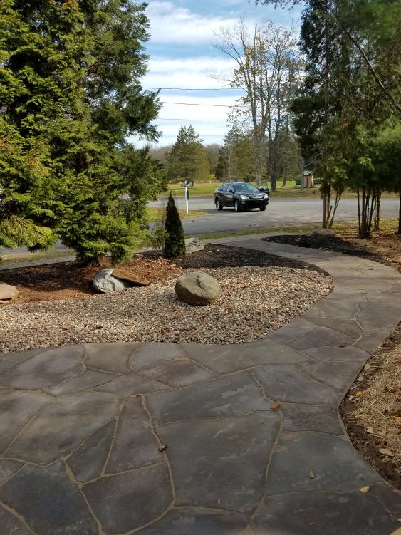Hardscaping with river rock and Flagstone reduce maintenance tasks.