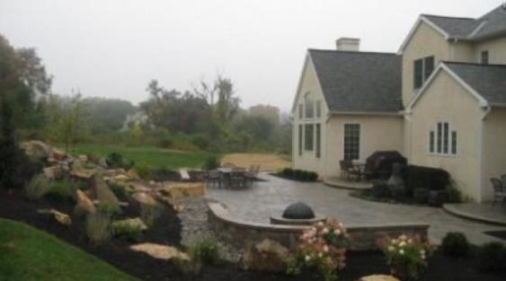 Malvern patio with sitting wall, firepit and waterfall.