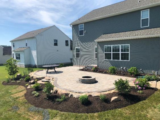 This curved patio in Douglassville is installed with Techo-bloc Blu 60 pavers and the shape lends itself well for seating around the firepit.