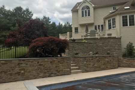 Stone veneer retaining wall and pool in Schwenksville, PA