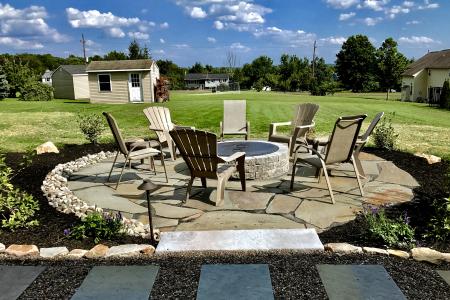 Fire pit in Gilbertsville, PA with chairs and flagstone pavers