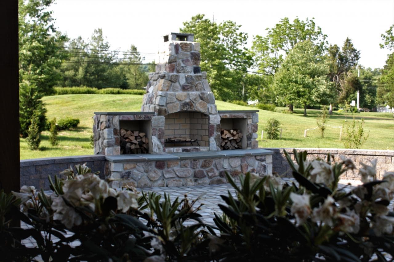 Custom natural stone fireplace with wood storage is the focal point for this Schwenksville, PA patio.