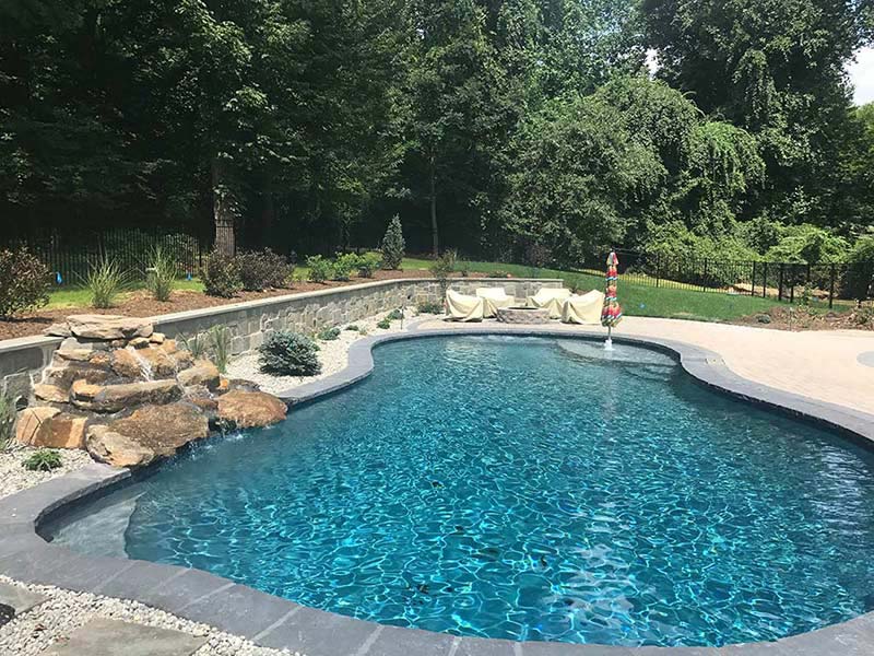 Glenmoore pool installation with waterfall and landscaping