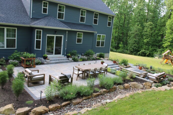 Large patio and planting beds replace lawn.