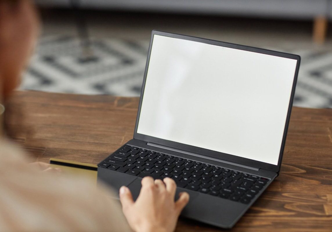 A Person Sitting at a Desk with a Laptop and a Credit Card Free Stock Photo by Everypixel